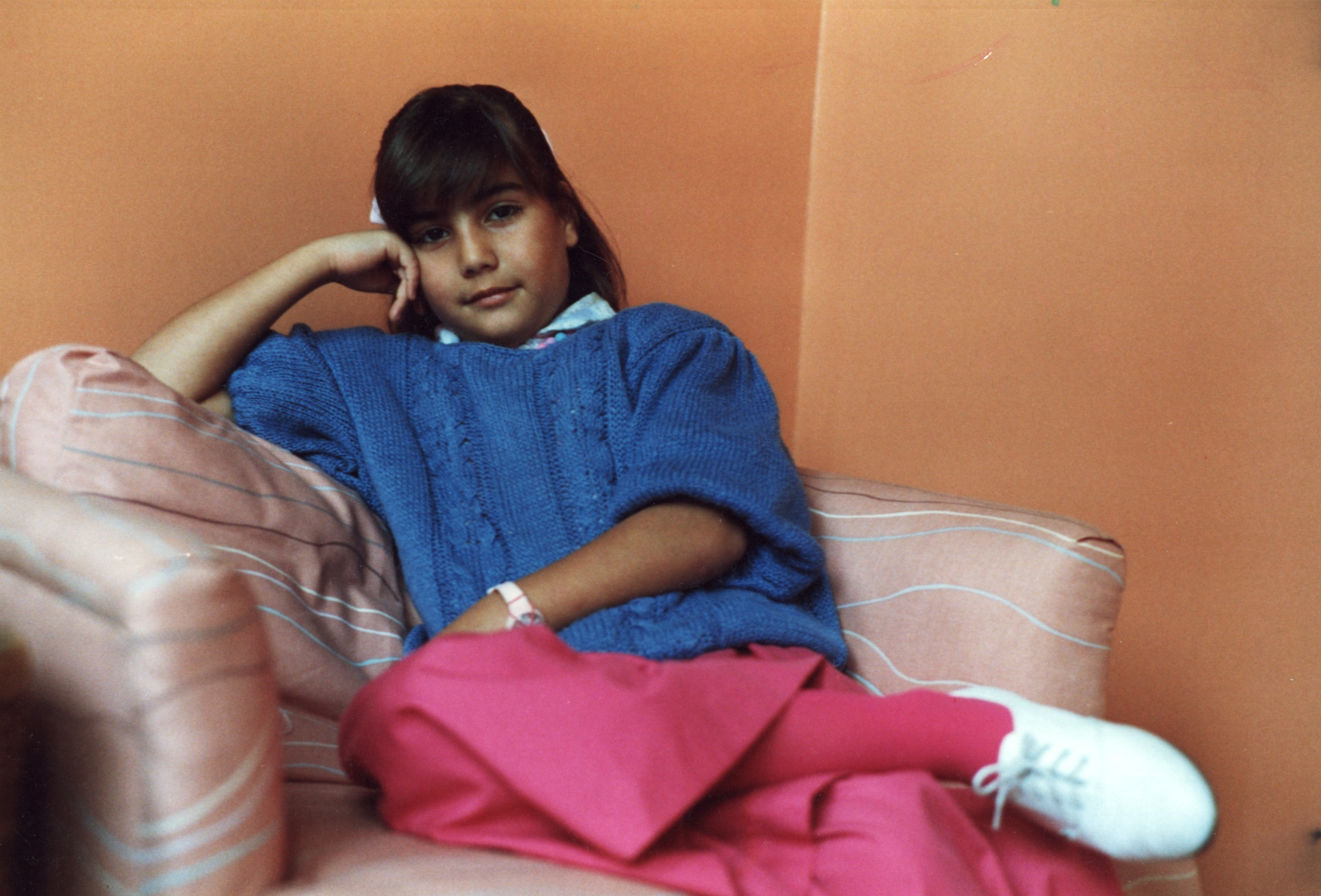 Young Camille relaxing on a pink striped sofa in Sydney, Australia